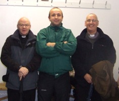 The Very Rev Tony Devlin (left) and Archdeacon Stephen McBride (right) with a team coach in the dressing room before St Comgall's GAA Club's game at Casement Park.